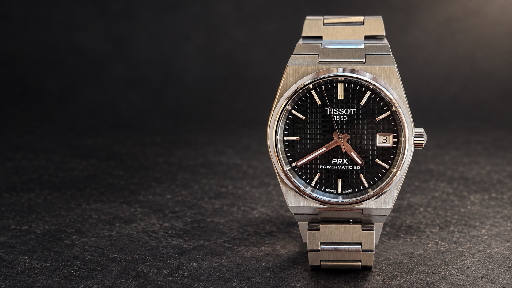 AI-composed illustration based on a photograph of a black-dial Tissot PRX 35mm Powermatic 80, against dark stone.